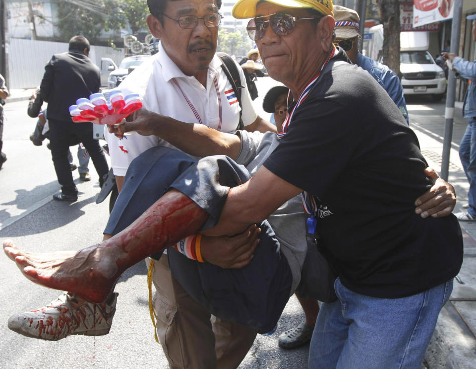 An anti-government protester injured in an explosion is carried by his fellow protesters during a demonstration in Bangkok, Thailand, Friday, Jan. 17, 2014. Dozens of people were wounded when an explosion hit anti-government demonstrators marching through Bangkok in some of the bloodiest violence reported this year. (AP Photo/Astv Manager Newspaper) THAILAND OUT