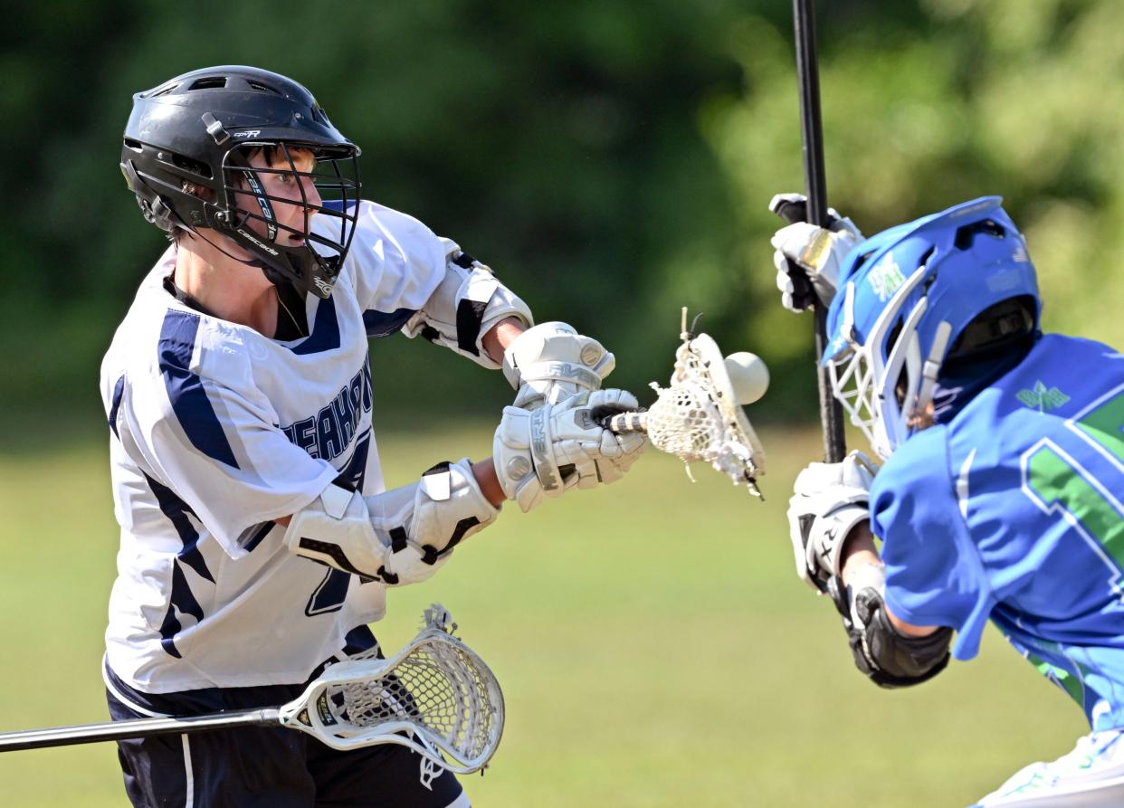 Harrison Barbieri of Cape Cod Academy puts a shot past Patrick Crowley of Blue Hills Regional Voc. Tech.