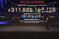 CORRECTS THE TITLE OF LIU HUI - Liu Hui, Director of JD Consumption and Industrial Development Research Institute, speaks in front of a display showing live sales figures for China's biggest online shopping day, known as "Singles' Day" at an empty hall of the headquarters of online retailer JD.com in Beijing, Thursday, Nov. 11, 2021. China's biggest online shopping day, known as "Singles' Day" on Nov. 11, is taking on a muted tone this year as regulators crack down on the technology industry and President Xi Jinping pushes for "common prosperity." (AP Photo/Andy Wong)