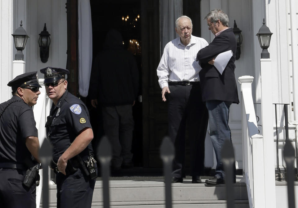 In this May 5, 2013 photo, funeral director Peter Stefan, second from right speaks to a man on the steps of his Graham, Putnam & Mahoney funeral home, in Worcester, Mass., while handling funeral arrangements for a suspect in the Boston Marathon bombing. Stefan said he was besieged by criticism, picketers and angry phone calls from people who called him a "traitor" and "un-American. A year later, he is writing a book about his experience. (AP Photo/Steven Senne)