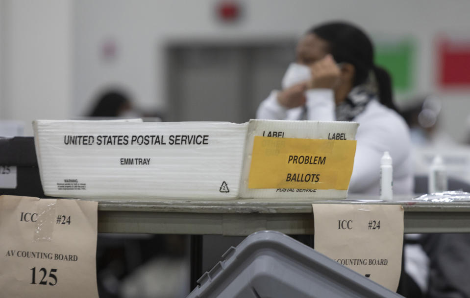 A box labeled for problem ballots sits on a table while election workers sort through absentee ballots in Detroit. 