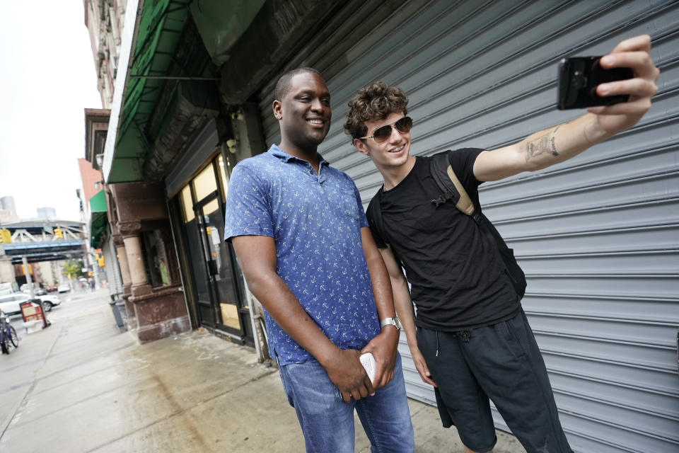 U.S. Rep. Mondaire Jones, D-N.Y., left, takes a selfie with one of his campaigns canvassers during a canvass kick-off on the Lower East Side of Manhattan, Monday, Aug. 22, 2022, in New York. Jones is running in the crowded Democratic congressional primary for New York's 10th District. (AP Photo/Mary Altaffer)