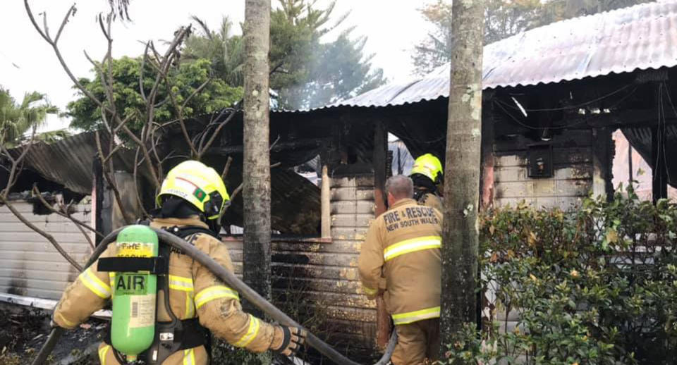 Fire fighters go into Fig Tree after it was burned down.