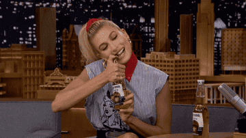 Hailey Baldwin Bieber opening a Corona with her teeth.