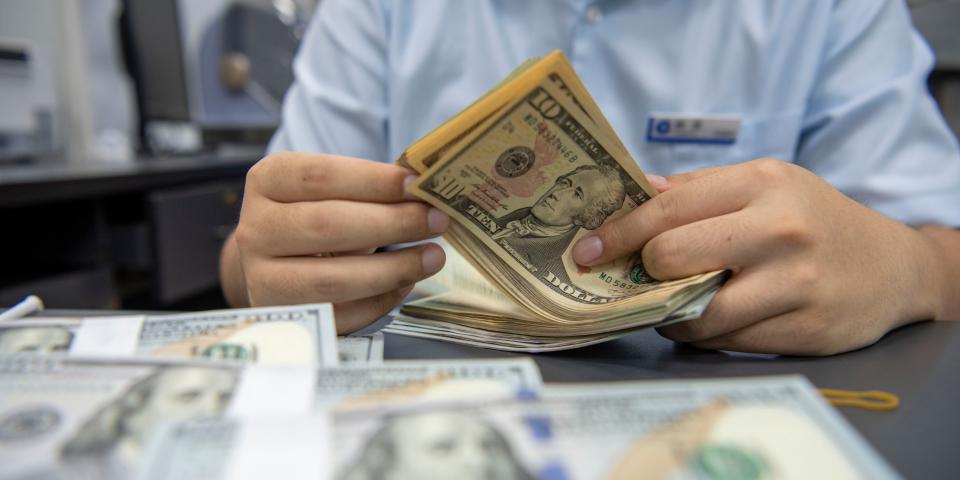 A staff member counts US dollar cash at a bank in Hai 'an, Jiangsu Province, China, Sept 5, 2022.