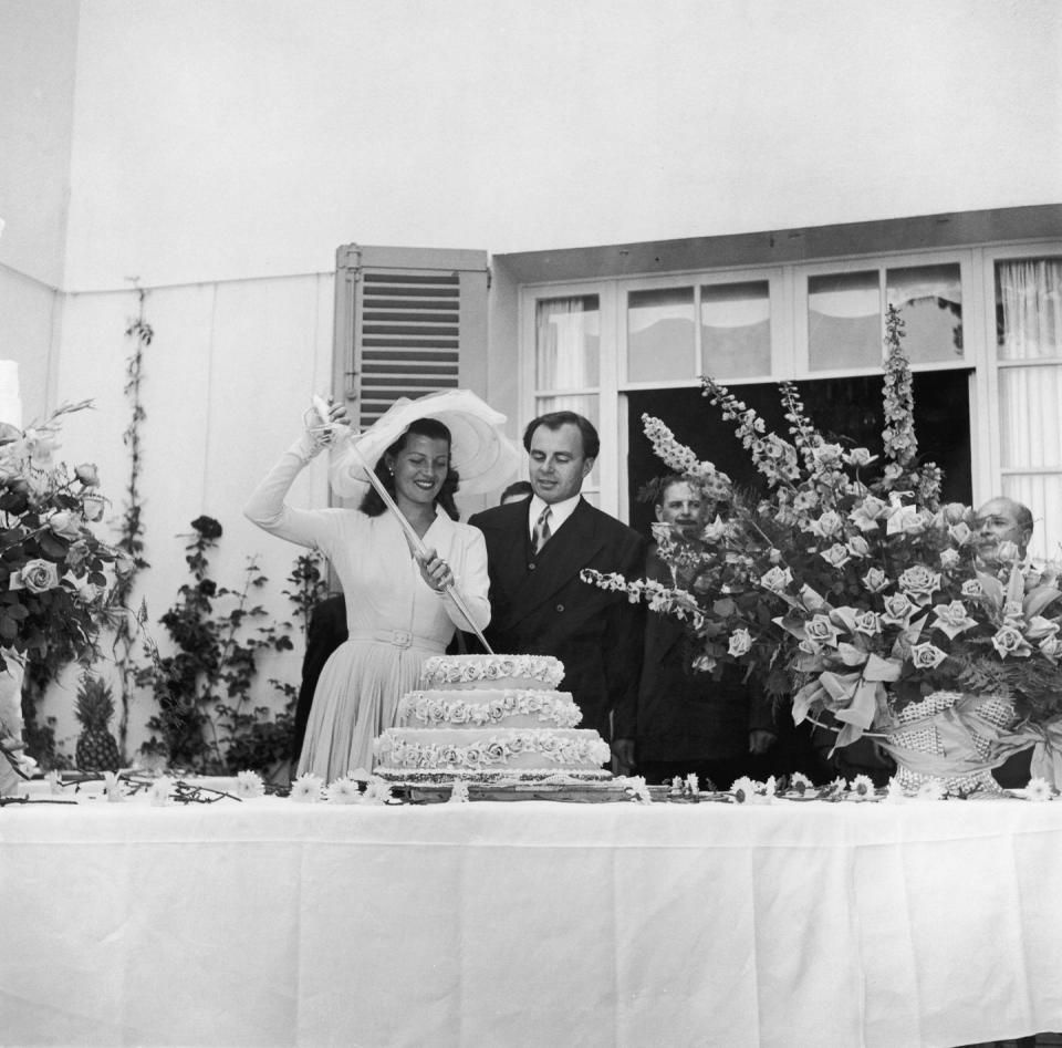 <p>Hollywood film star Rita Hayworth met Prince Aly Khan while visiting the French Rivera. The couple wed shortly after in 1949 in the South of France, naturally. Here, they cut the cake with a sword on their wedding day. They had one child together, a daughter, and were married until 1953.</p>