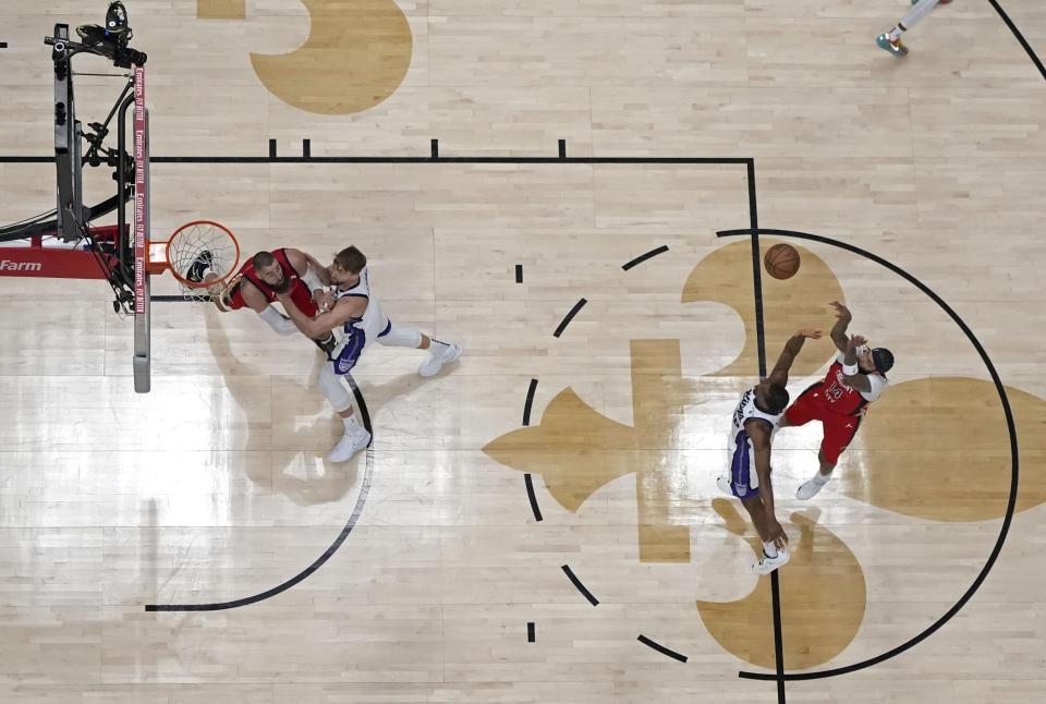 New Orleans Pelicans forward Brandon Ingram (14) shoots over Sacramento Kings forward Harrison Barnes as Pelicans center Jonas Valanciunas blocks out Sacramento Kings forward Domantas Sabonis in the first half of an NBA basketball play-in tournament game in New Orleans, Friday, April 19, 2024. The Pelicans won 105-98. (AP Photo/Gerald Herbert)