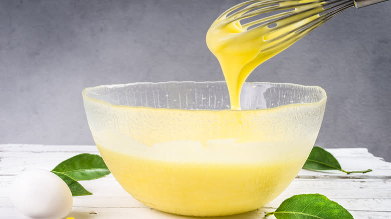 Whisk dripping lemon cream into a bowl