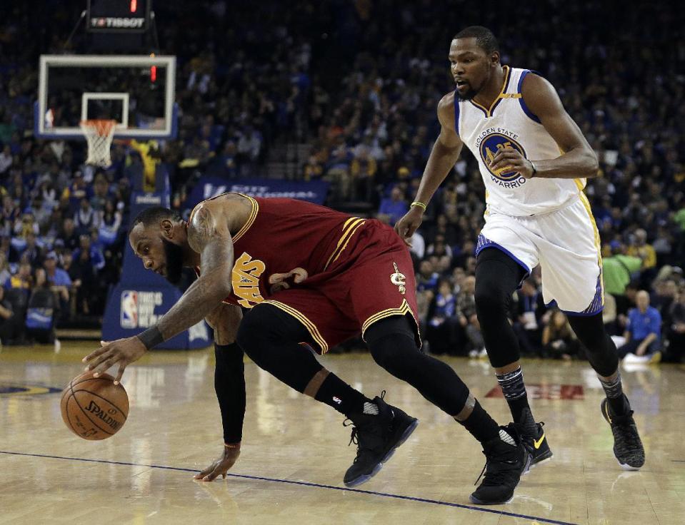 Cleveland Cavaliers' LeBron James, left, slips while driving the ball away from Golden State Warriors' Kevin Durant (35) during the first half of an NBA basketball game, Monday, Jan. 16, 2017, in Oakland, Calif. (AP Photo/Ben Margot)