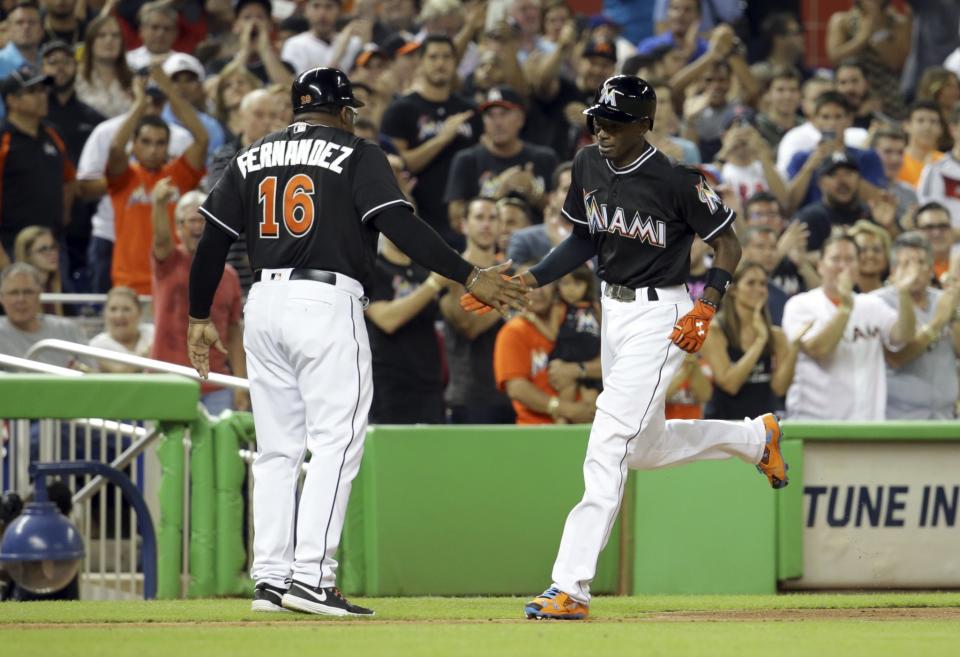 <p>Miami Marlins Dee Gordon, right, shakes hands with third base coach Lenny Harris, left, after he hit a solo home run during the first inning in a baseball game against the New York Mets, Monday, Sept. 26, 2016, in Miami. (AP Photo/Lynne Sladky) </p>