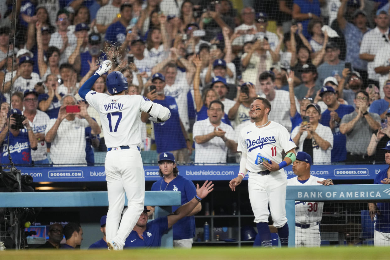 Los Angeles Dodgers designated hitter Shohei Ohtani (17) celebrates with Miguel Rojas (11) after hitting a home run during the sixth inning of a baseball game against the Cleveland Guardians in Los Angeles, Friday, Sept. 6, 2024. (AP Photo/Ashley Landis)