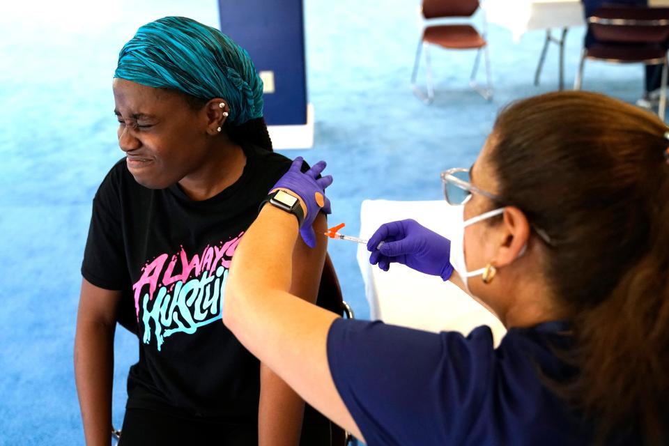 Student Rose Jean-Mary, 19, receives a shot of the Pfizer COVID-19 vaccine from registered nurse Isabel Ruiz at St. Thomas University on Aug. 20 in Miami. The university offered a pop-up vaccination site for students on move-in day in preparation for the first day of school Aug. 23.