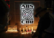 Supporters of ABS-CBN take photos of candles outside their headquarters in Quezon City, Philippines, Friday July 10, 2020. Philippine lawmakers voted Friday to reject the license renewal of the country's largest TV network ABS-CBN, shutting down a major news provider that had been repeatedly threatened by the president over its critical coverage. Sign reads "Bring back ABS-CBN".(AP Photo/Aaron Favila)