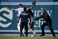 A fan is grabbed by security as she approaches Los Angeles Dodgers right fielder Cody Bellinger during the ninth inning of a baseball game against the Colorado Rockies, Sunday, June 23, 2019, in Los Angeles. (AP Photo/Mark J. Terrill)