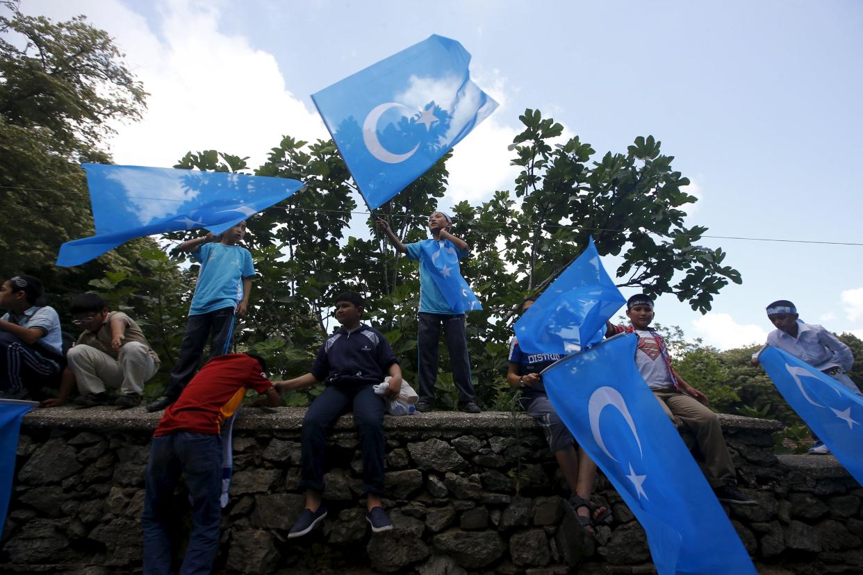 Boys wave East Turkestan flags during a protest against China near the Chinese Consulate in Istanbul, Turkey, July 5, 2015.