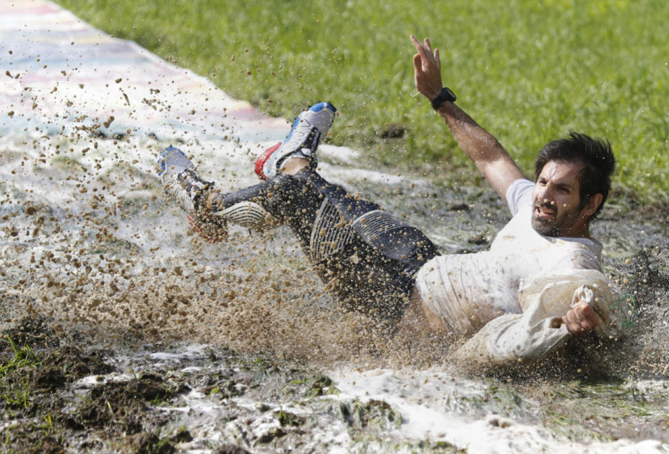 A participant of an obstacle extreme run ‘Bison race’ slips in mud while carrying a heavy sack with sand in Logoisk, 40 km from Minsk, Belarus, May 8, 2016. (TATYANA ZENKOVICH/EPA)