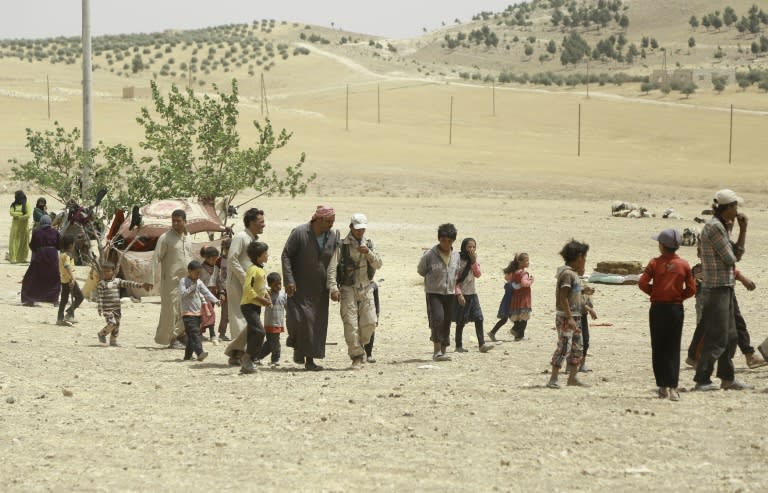 Syrian families fleeing an assault launched by Arab and Kurdish forces against IS group fighters in the town of Manbij, arrive at an encampment on the outskirts in June