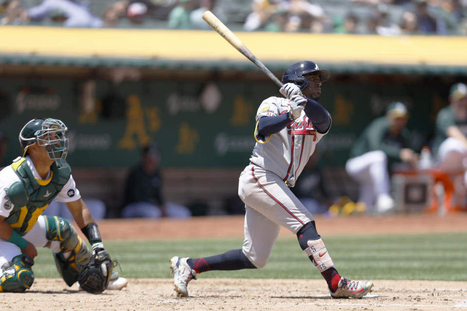 Atlanta Braves' Ozzie Albies, right, hits a two-run home run in front of Oakland Athletics catcher Carlos Perez, left, during the fifth inning of a baseball game in Oakland, Calif., Thursday, May 31, 2023. (AP Photo/Jed Jacobsohn)