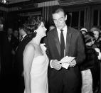 <p>At the 1962 premiere of <em>Dr. No, </em>James Bond actor Sean Connery reviews his tickets while co-star Zena Marshal looks on. The film served as the first big-screen outing for Agent 007 and has since spawned 25 James Bond sequels. </p>