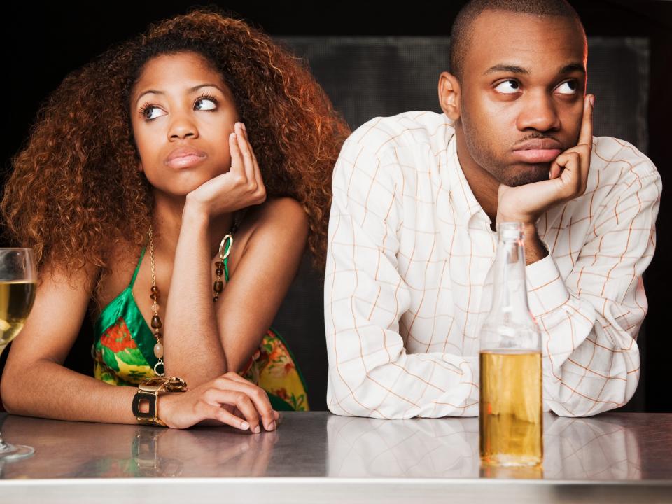 Man and woman looking bored at a bar