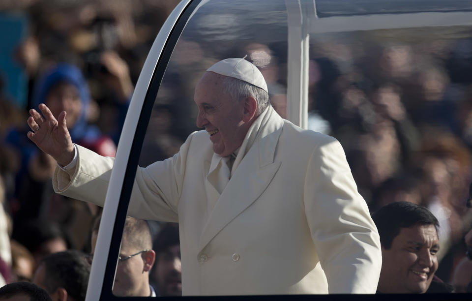 Rev. Fabian Baez, bottom right, sits behind Pope Francis on his popemobile as he arrives for his weekly general audience in St. Peter's Square at the Vatican, Wednesday, Jan. 8, 2014. Pope Francis has broken with papal protocol once again, inviting his friend Rev. Fabian Baez, a priest from Francis’ hometown in Buenos Aires, for a spin on his popemobile. (AP Photo/Alessandra Tarantino)