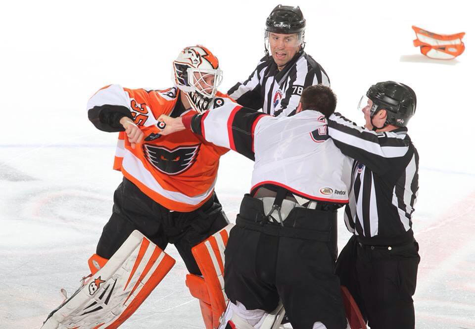 Dover resident and Portsmouth High School graduate Jeremy Lovett, back, tries to break up a fight during an American Hockey League game in 2015.