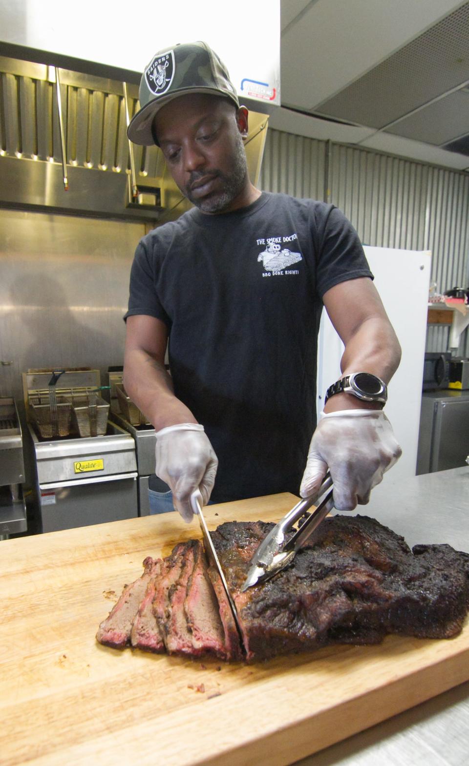 Cornell Clark, The Smoke Doctor, carves brisket of beef at his restaurant by the same name in Hamburg Township Wednesday, March 10, 2021.