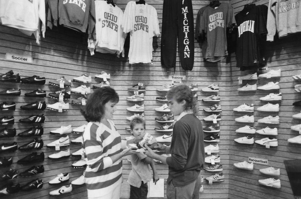 Marian Calvin and her sons Daniel, 9, and David, 16, look at shoes during back-to-school shopping Aug. 25, 1987, at the Athlete's Foot at Rolling Acres Mall in Akron.