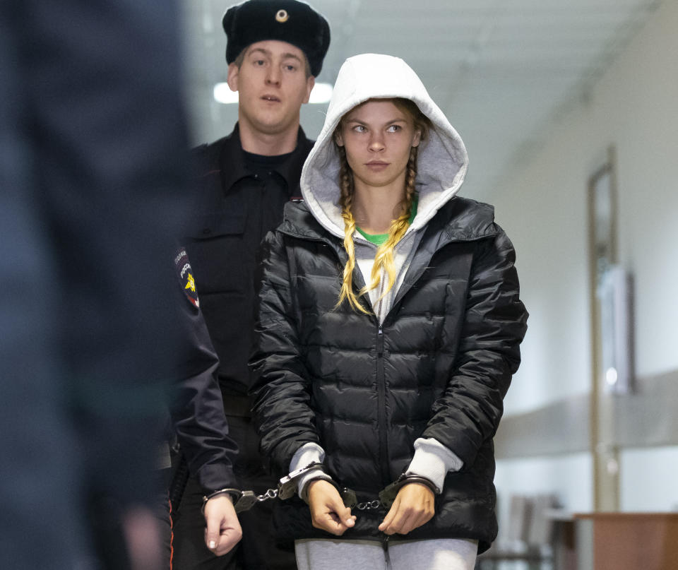 Anastasia Vashukevich, also known on social media as Nastya Rybka is escorted in the court room in Moscow, Russia, Saturday, Jan. 19, 2019. The Belarusian model Vashukevich, who claimed last year that she had evidence of Russian interference in the election of Donald Trump as U.S. president, was arrested upon arrival in Moscow on Thursday following deportation from Thailand. (AP Photo/Alexander Zemlianichenko)