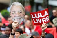 A supporter of former president Luiz Inacio Lula da Silva holds a mask of the leftist leader and a sign reading "Lula Free" during a rally outside the metalworkers' union in Sao Bernardo do Campo, in metropolitan Sao Paulo, on November 9, 2019