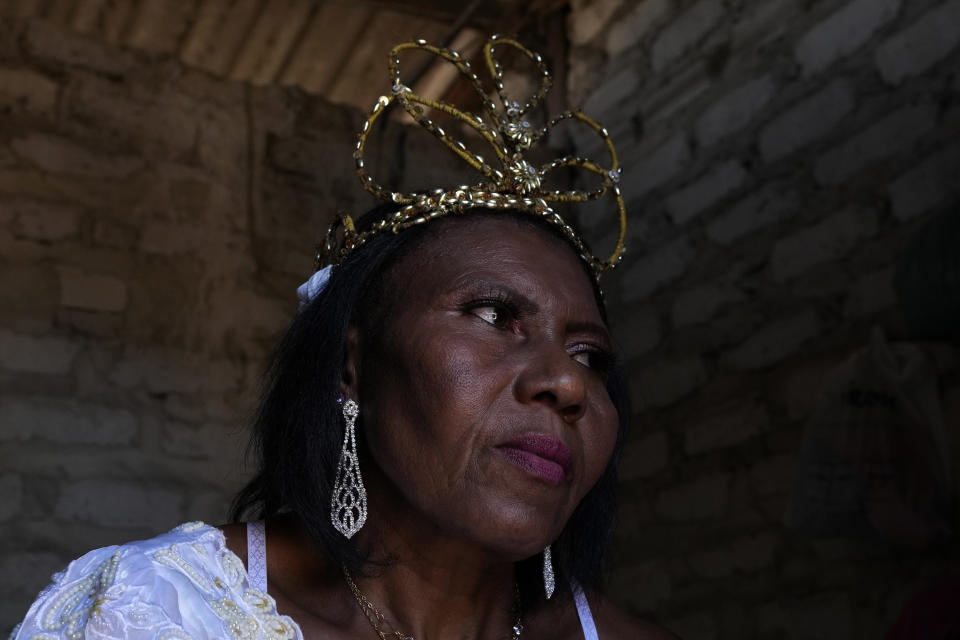 Nilda dos Santos receives her Queen's crown in the Kalunga quilombo, the descendants of runaway slaves, during the culmination of the week-long pilgrimage and celebration for the patron saint "Nossa Senhora da Abadia" or Our Lady of Abadia, in the rural area of Cavalcante in Goias state, Brazil, Monday, Aug. 15, 2022. Devotees, who are the descendants of runaway slaves, celebrate Our Lady of Abadia at this time of the year with weddings, baptisms and by crowning distinguished community members, as they maintain cultural practices originating from Africa that mix with Catholic traditions. (AP Photo/Eraldo Peres)