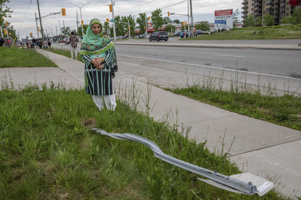 Torpenky Khan, a Muslim, looks at a street sign that was destroyed during the attack.