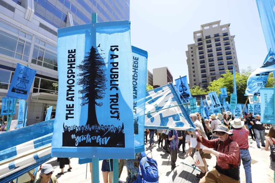 FILE - In this June 4, 2019, file photo, supporters attend a rally for a group of young people who filed a lawsuit saying U.S. energy policies are causing climate change and hurting their future, in Portland, Ore. The divide in Oregon between the state’s liberal, urban population centers and its conservative and economically depressed rural areas makes it fertile ground for the political crisis unfolding over a push by Democrats to enact sweeping climate legislation. Just three years after armed militia members took over a national wildlife refuge in southeastern Oregon, some of the same groups are now seizing on a walkout by Oregon’s GOP senators to broadcast their anti-establishment message. (AP Photo/Steve Dipaola, File)