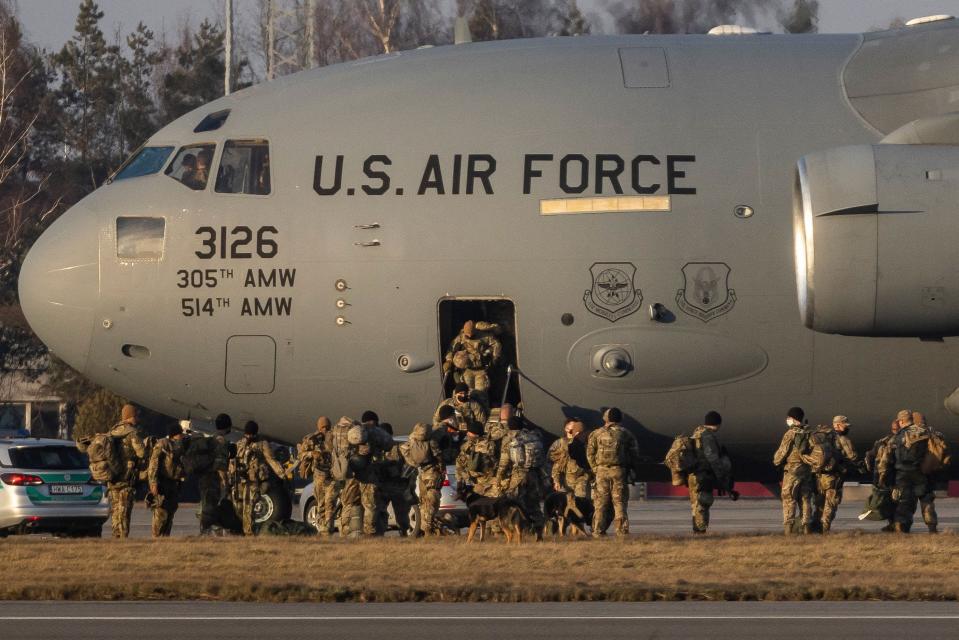 US soldiers disembark from a C-17 Globemaster cargo plane on the tarmac of Rzeszow-Jasionka Airport, southeastern Poland, on Feb. 16, 2022. Dozens of US paratroopers landed there as part of a deployment of several thousand sent to bolster NATO's eastern flank in response to tensions with Russia.