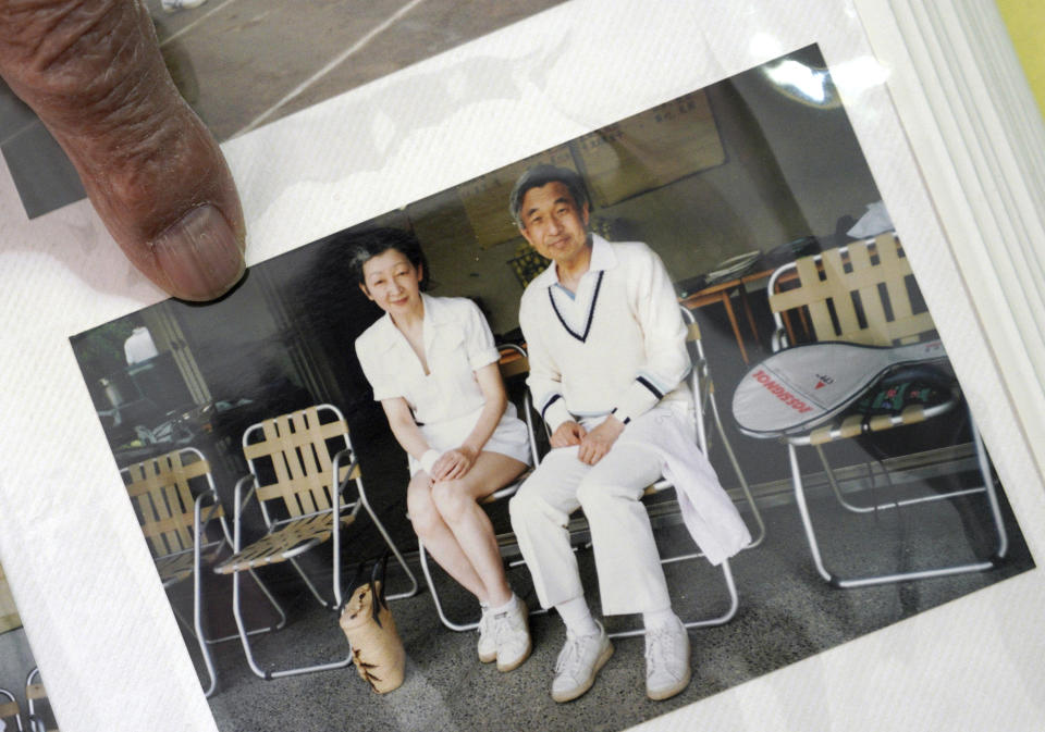 In this Feb. 3, 2019, photo, Kazuo Oda, a retired trading house executive and longtime tennis friend of Emperor Akihito, shows his photo of Akihito and Empress Michiko as they play tennis during an exclusive interview with the Associated Press in Tokyo. Akihito’s Heisei era will end when he abdicates on April 30 in favor of his elder son, 58-year-old Crown Prince Naruhito, beginning a new, as yet unnamed era. (AP Photo/Eugene Hoshiko)