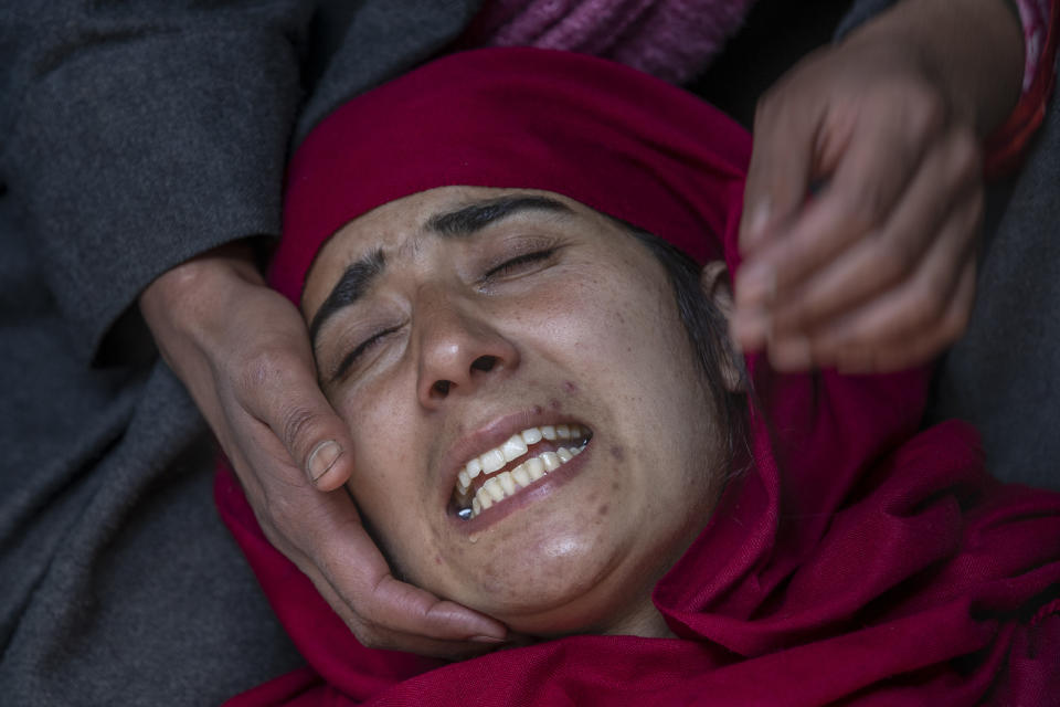 A Kashmiri woman wails outside a house allegedly ransacked by security forces after suspected militants killed a policeman, in Beerwah area, Indian controlled Kashmir, Friday, Feb. 19, 2021. Anti-India rebels in Indian-controlled Kashmir killed two police officers in an attack Friday in the disputed region's main city, officials said. Elsewhere in the Himalayan region, three suspected rebels and a policeman were killed in two gunbattles. (AP Photo/Dar Yasin)