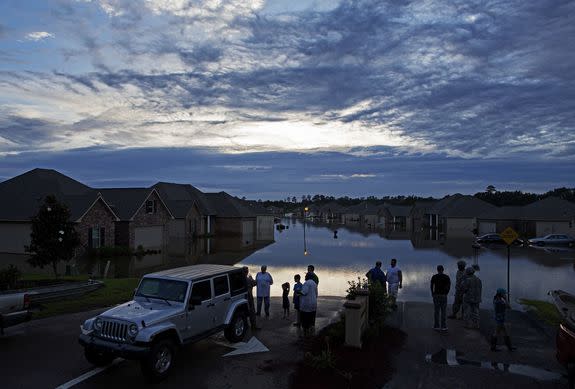 Residents line up on Providence Boulevard in Hammond, La., where flood waters inundated their homes after heavy rains in the region Saturday.