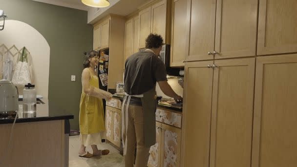 PHOTO: Justine Gelbolinga and Armando Alvarez cook together in their kitchen. (ABC News)