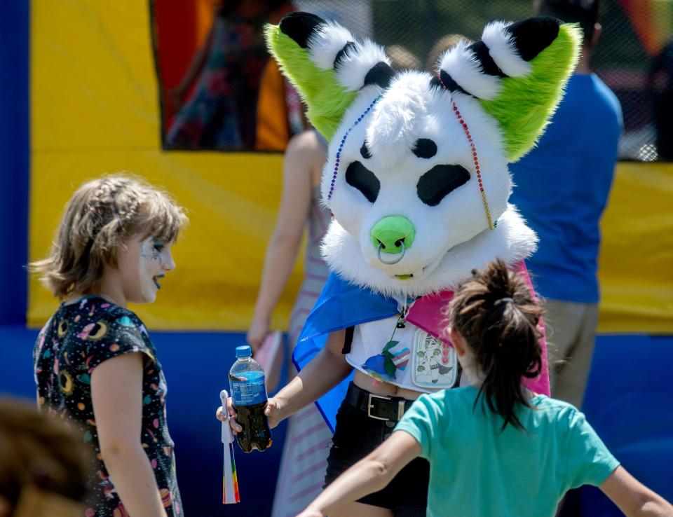 Kade Petersimes of East Peoria chats with a pair of youngster through her alternative persona Babo, a furry creature, during the River City Pride Festival on Saturday, Aug. 3, 2019 at Glen Oak Park Amphitheatre.