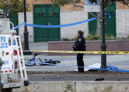 <p>A New York Police Department officer stands next to a body covered under a white sheet near a mangled bike along a bike path on Oct. 31, 2017, in New York. (Photo: Bebeto Matthews/AP) </p>