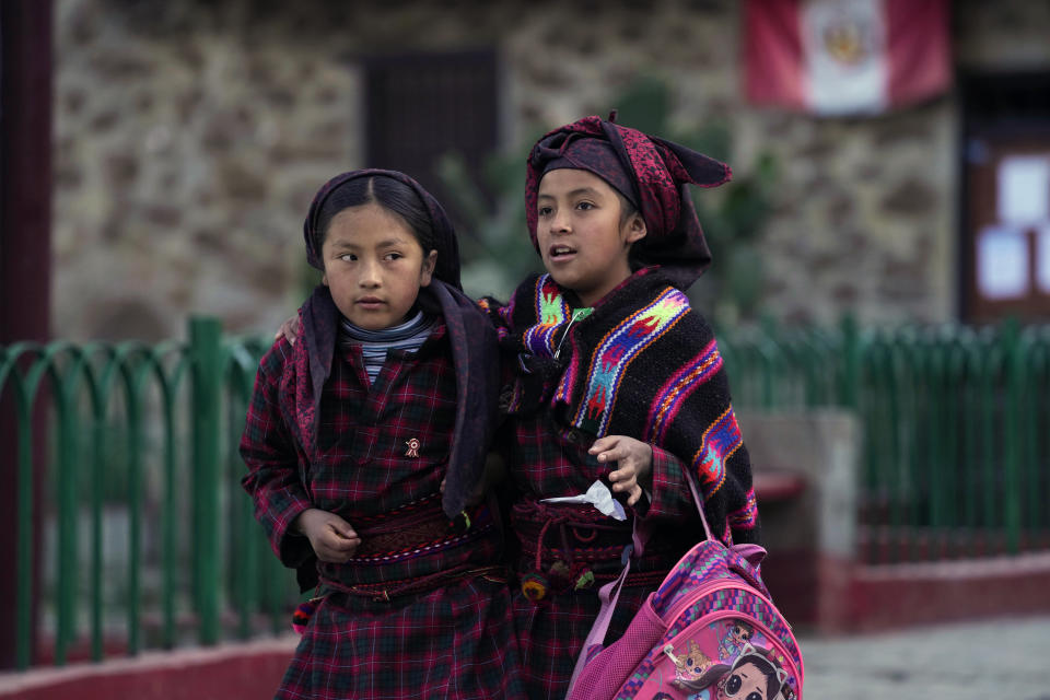 Girls walk to school in Tupe, Peru, Tuesday, July 19, 2022. As Peru´s President Pedro Castillo marks the first anniversary of his presidency, his popularity has been decimated by his chaotic management style and corruption allegations, but in rural areas like Tupe, voters believe the fault for the executive crisis lies not only with Castillo, but with Congress, which has sought to remove him twice. (AP Photo/Martin Mejia)