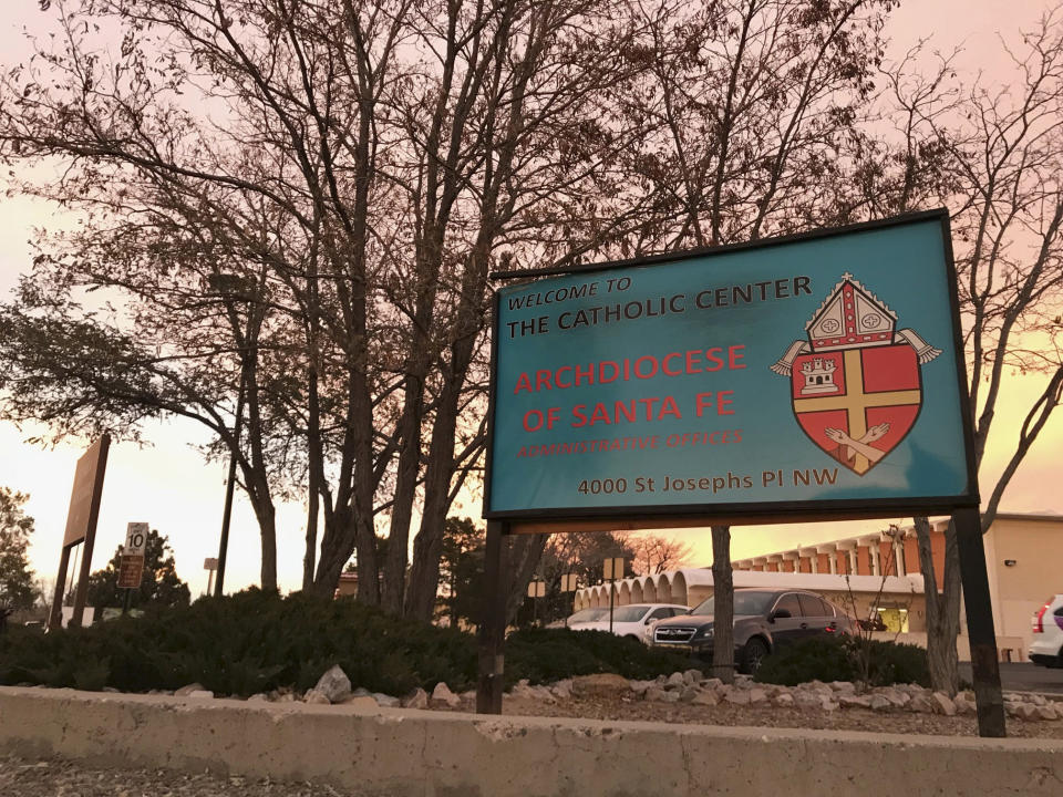 The sun sets on a sign in front of the Archdiocese of Santa Fe offices in Albuquerque, N.M., on Thursday, Nov. 29, 2018. Archbishop John Wester announced Thursday that the archdiocese will be filing for Chapter 11 bankruptcy protection next week, as the Catholic church in New Mexico has settled numerous claims of sexual abuse by clergy over the years and is close to depleting its reserves. (AP Photo/Susan Montoya Bryan)