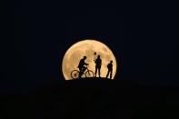 <p>The full moon rises behind silhouettes of people prior to the totally phase of Century’s longest ”Blood Moon” eclipse in Van, Turkey on July 27, 2018. (Photo: Ozkan Bilgin/Anadolu Agency/Getty Images) </p>