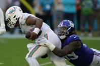 New York Giants defensive end Leonard Williams (99) sacks Miami Dolphins quarterback Tua Tagovailoa (1) during the second half of an NFL football game, Sunday, Dec. 5, 2021, in Miami Gardens, Fla. (AP Photo/Lynne Sladky)