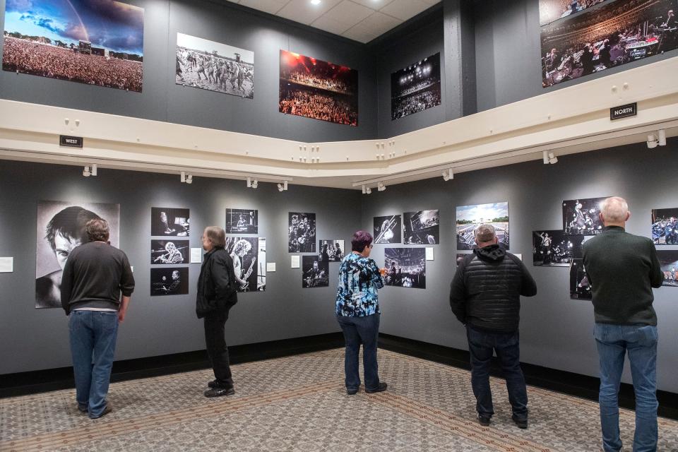 People look at some of the 62 pictures in the Tony Levin: A Life of Music & Photography exhibit at the Haggin Museum in Stockton on Thursday, Feb. 16, 2023. Rock bassist Tony Levin has taken photos from the stage as well as backstage over the past 40 years while touring with groups such as King Crimson, Peter Gabriel Band, and the Stick Men.