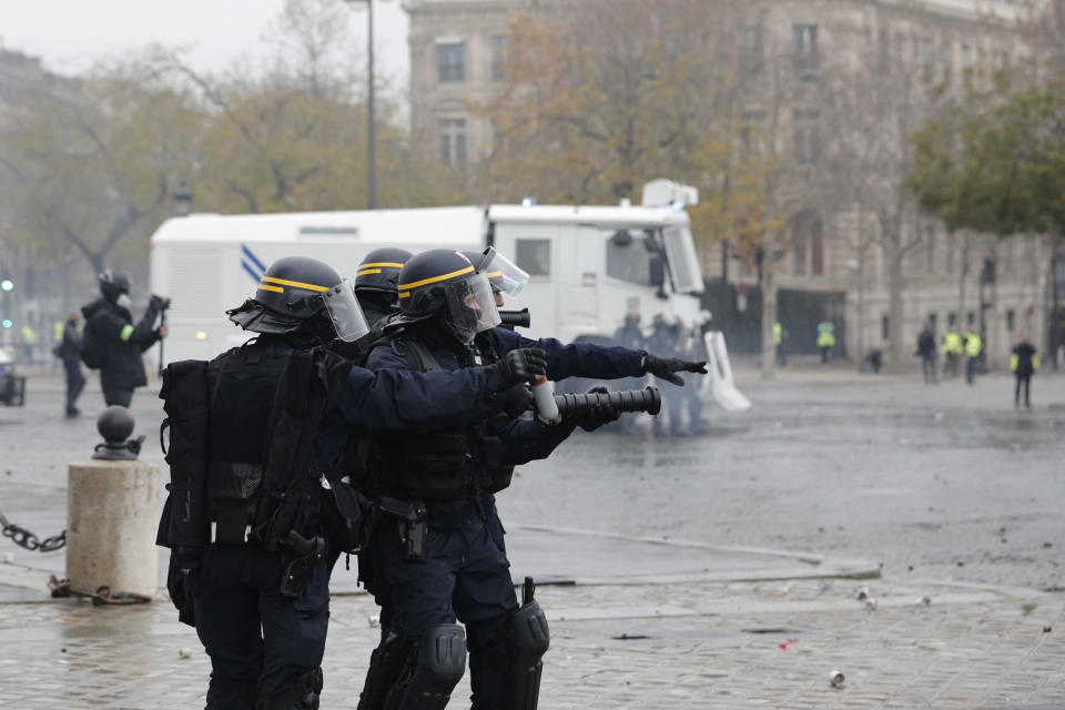 Riot police officers take position near the Arc de Triomphe during a demonstration Saturday, Dec.1, 2018 in Paris. French authorities have deployed thousands of police on Paris' Champs-Elysees avenue to try to contain protests by people angry over rising taxes and Emmanuel Macron's presidency. (AP Photo/Kamil Zihnioglu)