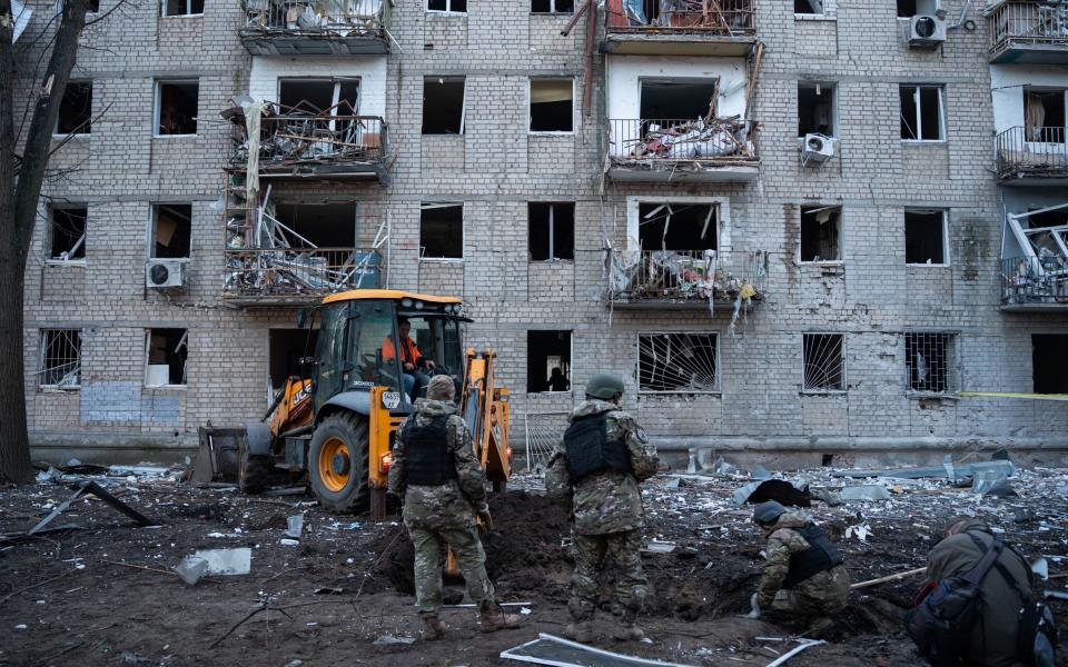 Military experts operate at the site of previous aerial bombing in Kharkiv, Ukraine.