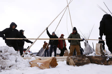 Members of the Oglala Lakota tribe erect a tipi inside of the Oceti Sakowin camp as "water protectors" continue to demonstrate against plans to pass the Dakota Access pipeline near the Standing Rock Indian Reservation, near Cannon Ball, North Dakota, U.S., December 2, 2016. REUTERS/Lucas Jackson