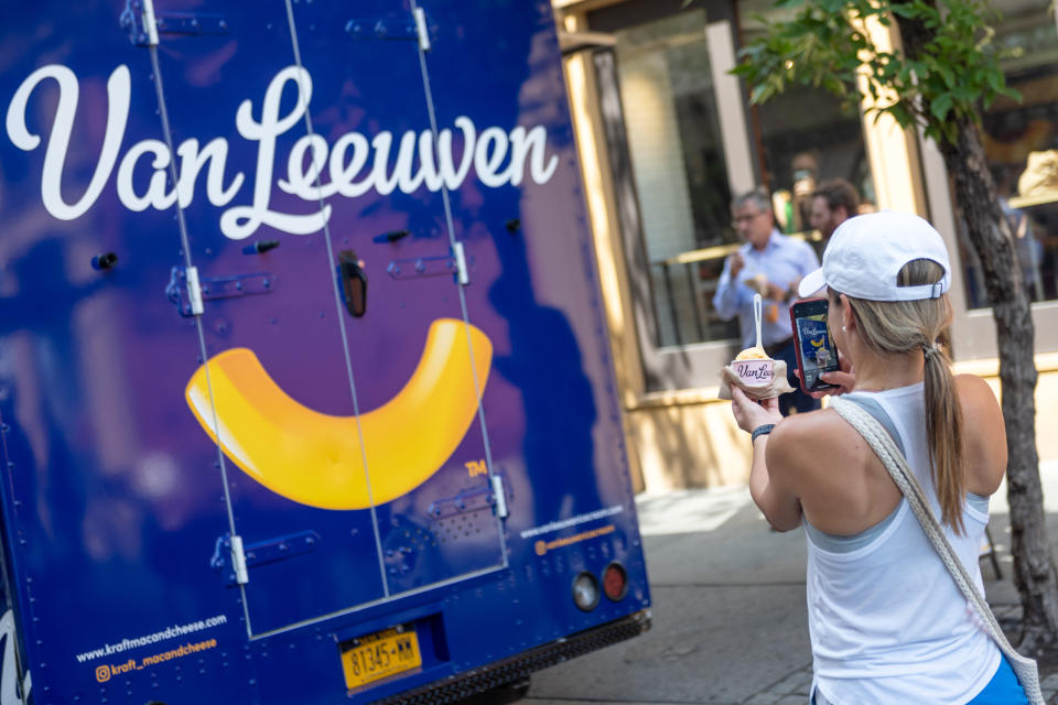 NEW YORK, NEW YORK - JULY 14: A woman takes a photo of Van Leeuwen's new Kraft mac and cheese flavor ice cream at a popup truck near Union Square on July 14, 2021 in New York City. The new flavor was released on July 14th in honor of National Macaroni and Cheese Day. (Photo by Alexi Rosenfeld/Getty Images)