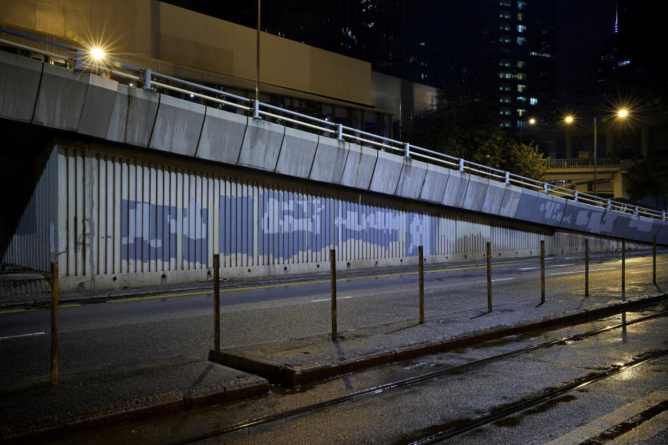 In this Sept. 19, 2019, photo, anti-government graffiti on an overpass wall are painted over after a weekend of protest in Hong Kong. As Hong Kong enters its fourth month of steady protests, the city is embracing for another violent weekend prior to the upcoming 70th National Day on Oct. 1. (AP Photo/ Vincent Yu)